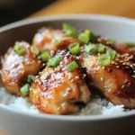 Overhead shot of 30-minute honey garlic chicken in a skillet with green onions and sesame garnish